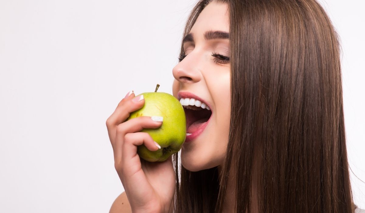 Female teeth and apple