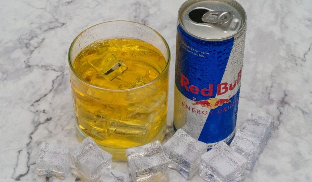 Aluminium can of Red Bull Energy drink with ice and drops 