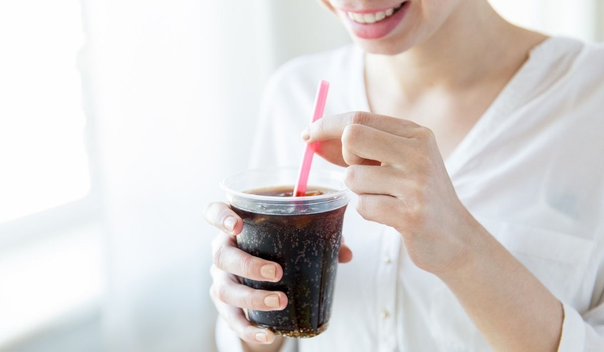 Close up of happy woman drinking coca cola