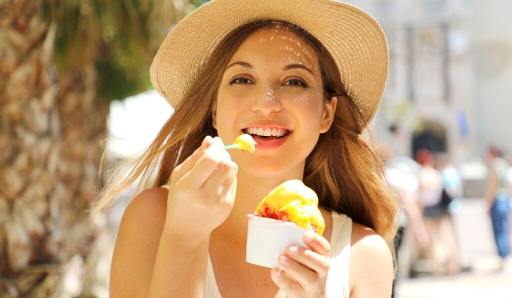 Close up of pretty tourist girl eating traditional gelato italian ice cream