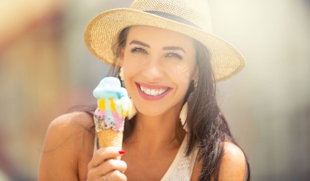 Portrait of a beautiful young woman eating ice cream