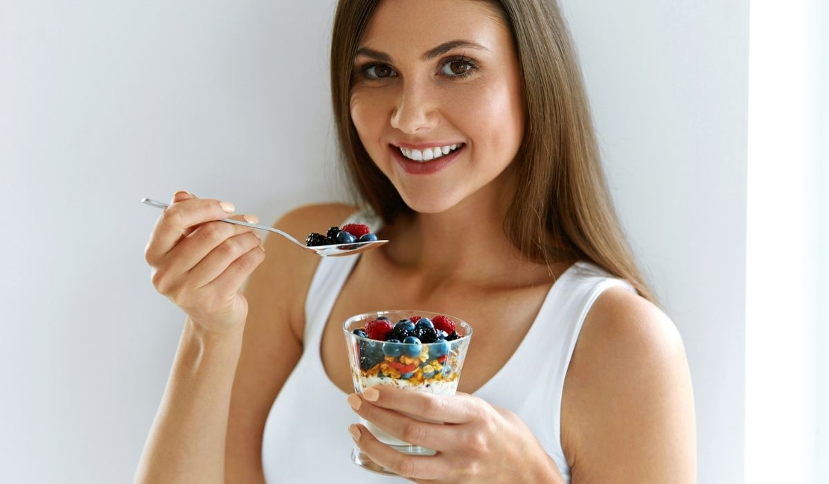 Woman Eating Yogurt, Berries And Oatmeal For Healthy Breakfast