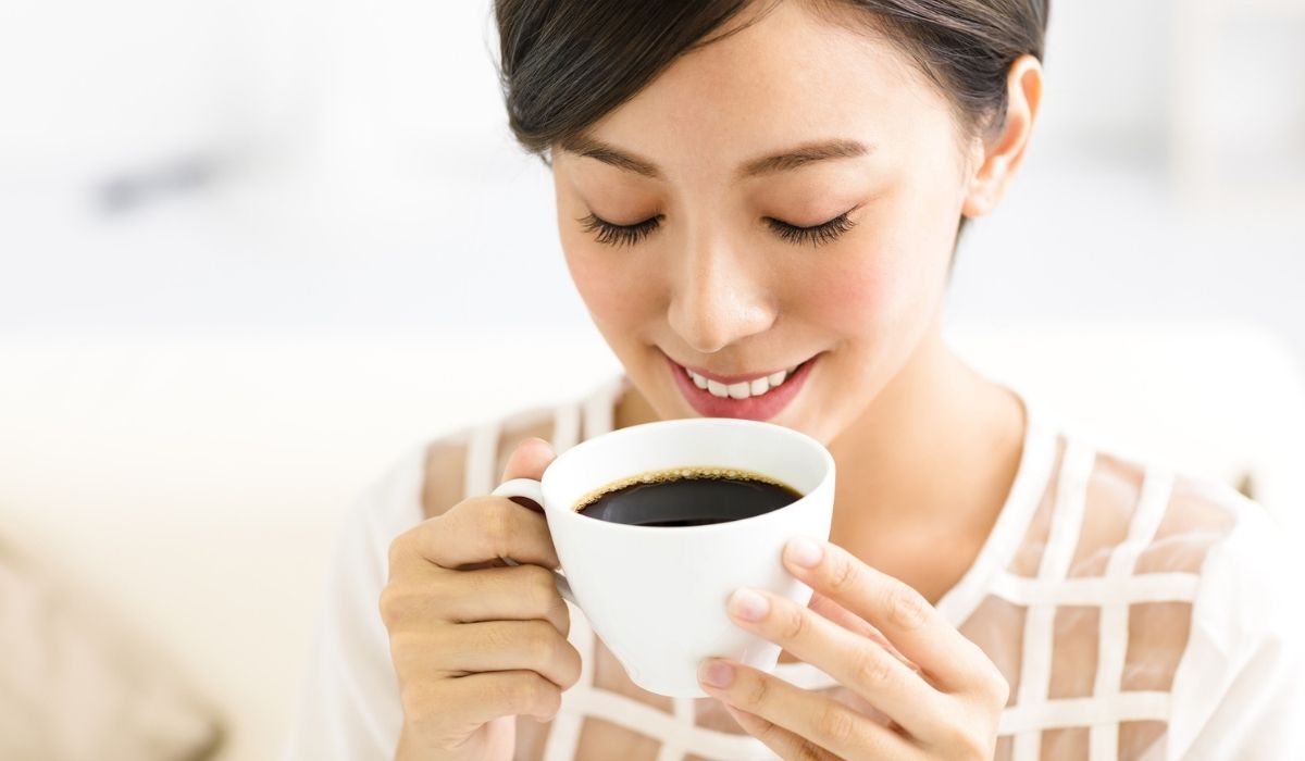 Young smiling woman drinking coffee in the morning