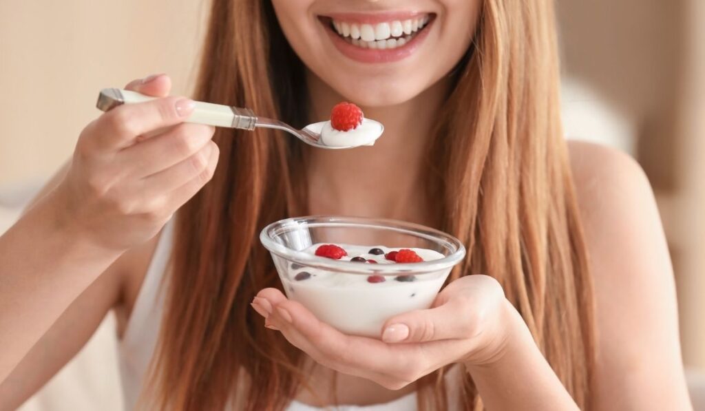 Young woman eating yogurt