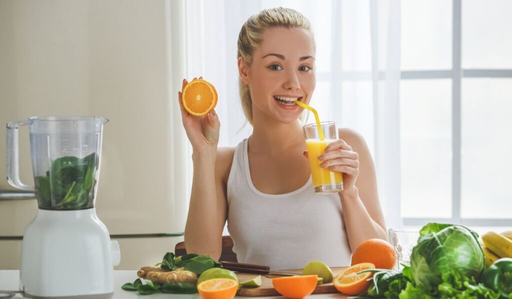 Young woman making detox smoothie at home 