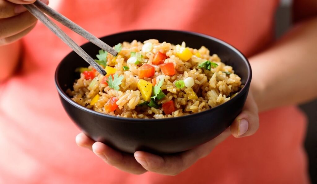 Eating fried rice with vegetables in a bowl