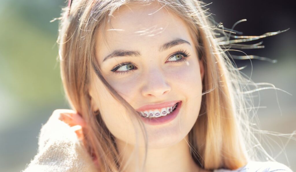 Beautiful young blonde girl wearing dental braces