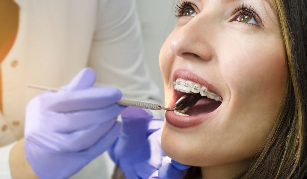 Closeup of beautiful girl on dental braces check up 