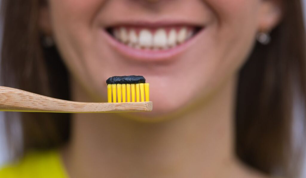 Close up of eco friendly bamboo toothbrush with black charcoal toothpaste