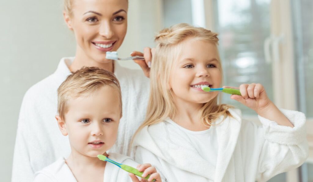 Kids with mother brushing teeth