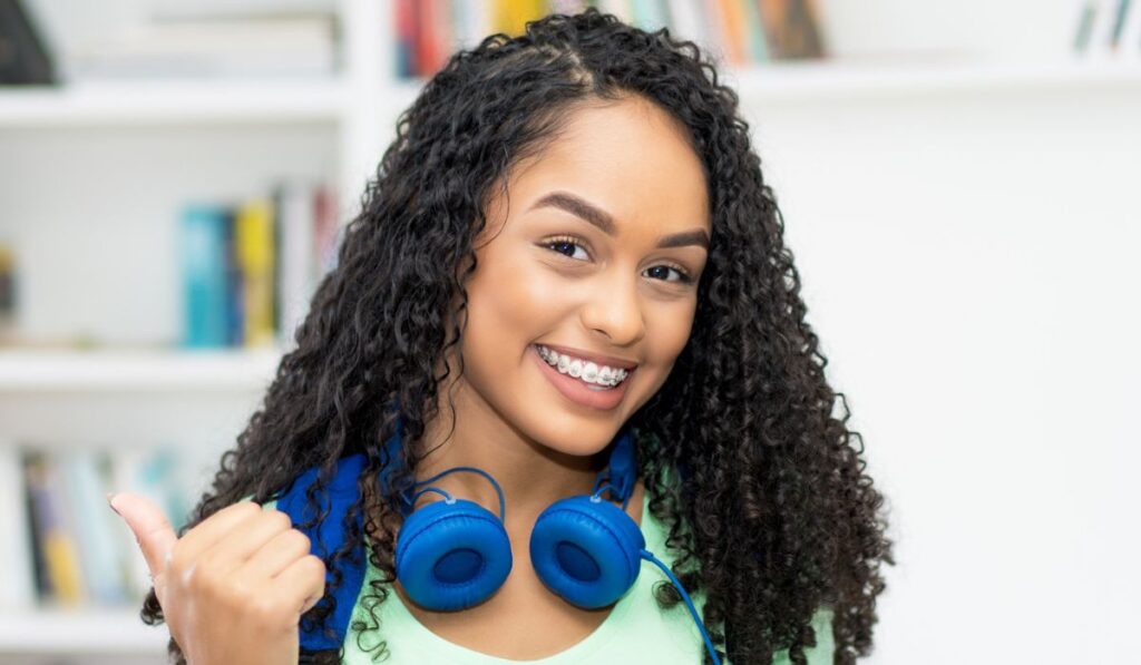 Beautiful brazilian female student with retainer and headphone