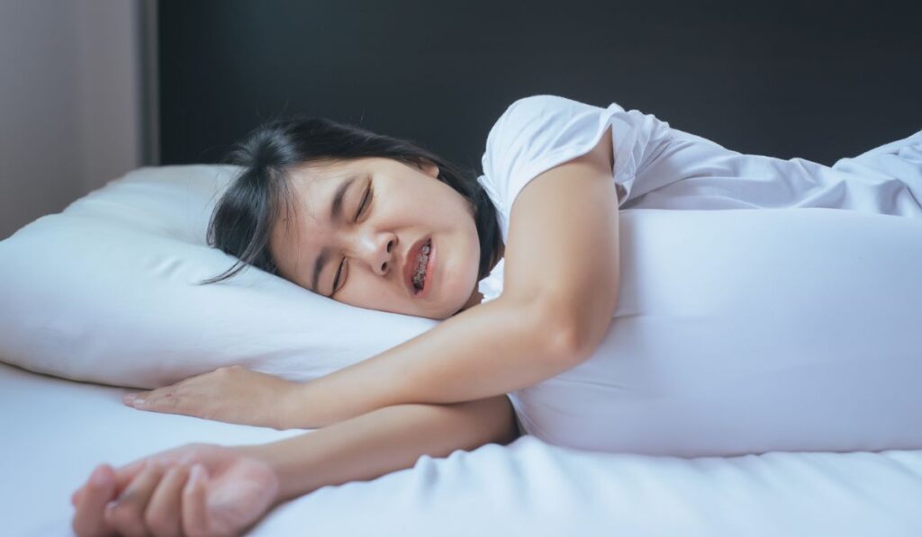 Female sleeping on the bed and grinding teeth