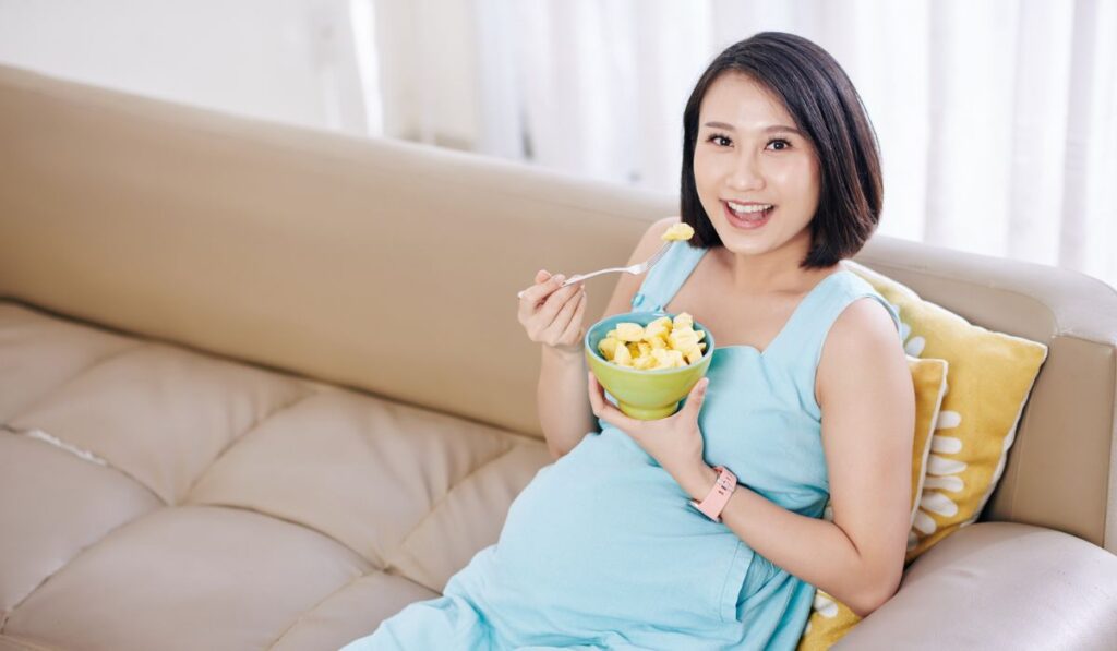 Pregnant woman eating pineapple