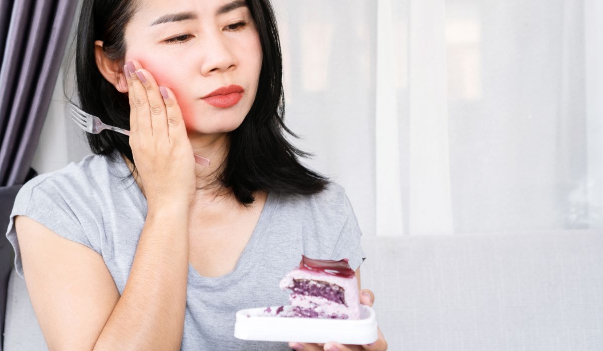 Asian woman sensitive to sugar have a toothache after eating sweets