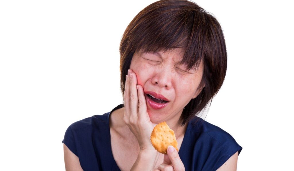 Asian women with intense toothache pain after biting cookie