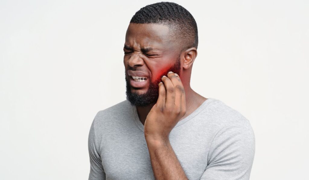 Young afro man having wisdom teeth problem